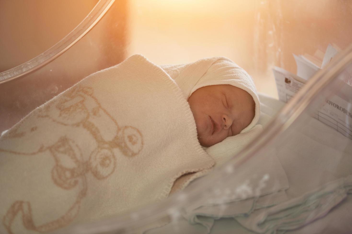 newborn baby sleeping in  bed at hospital photo