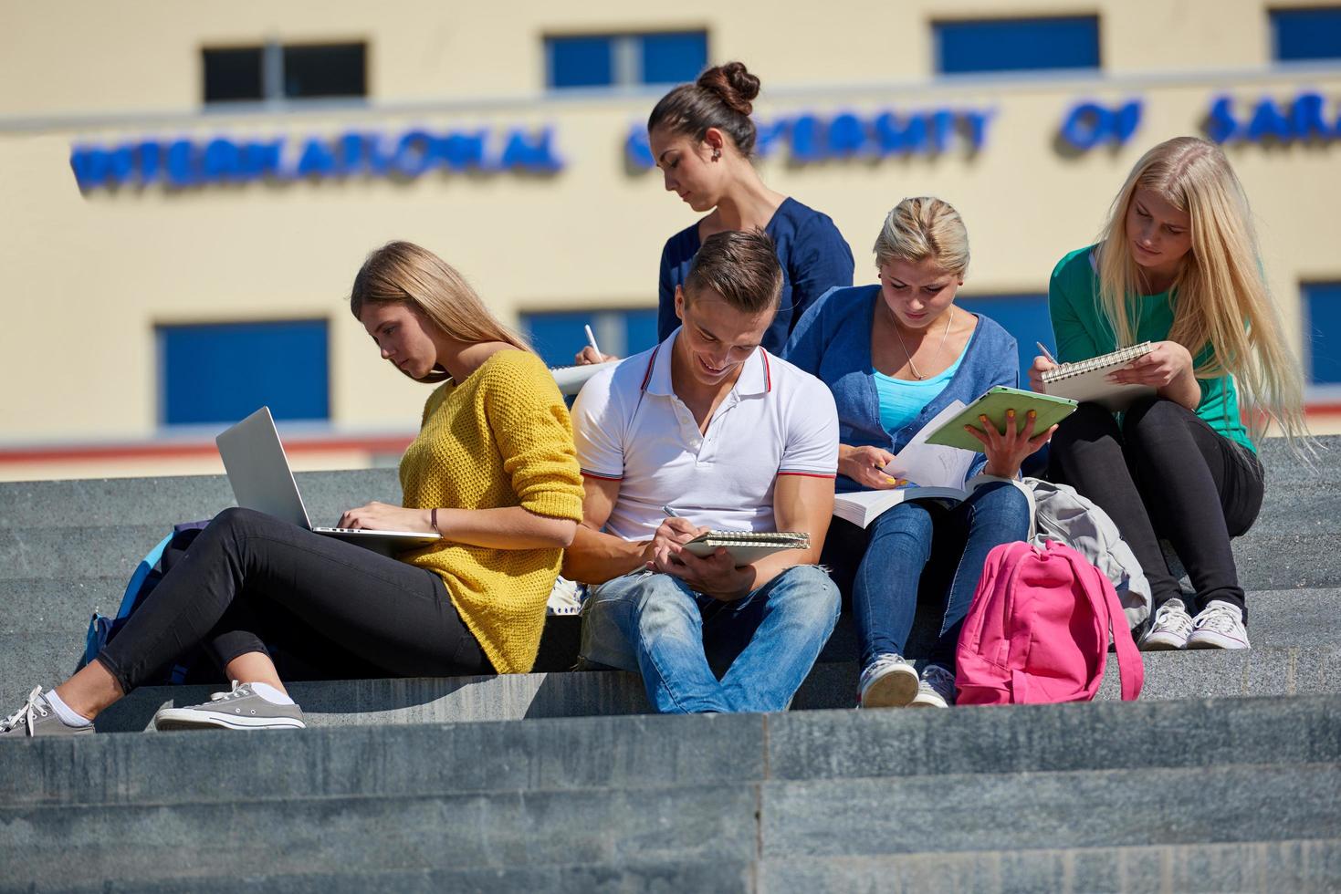 students outside sitting on steps photo