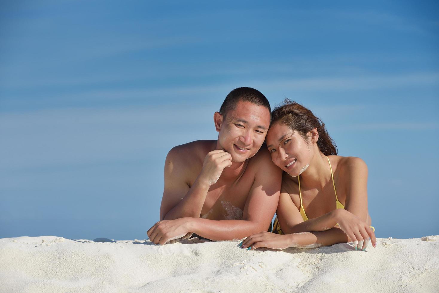 asian couple enjoying summer on beach photo