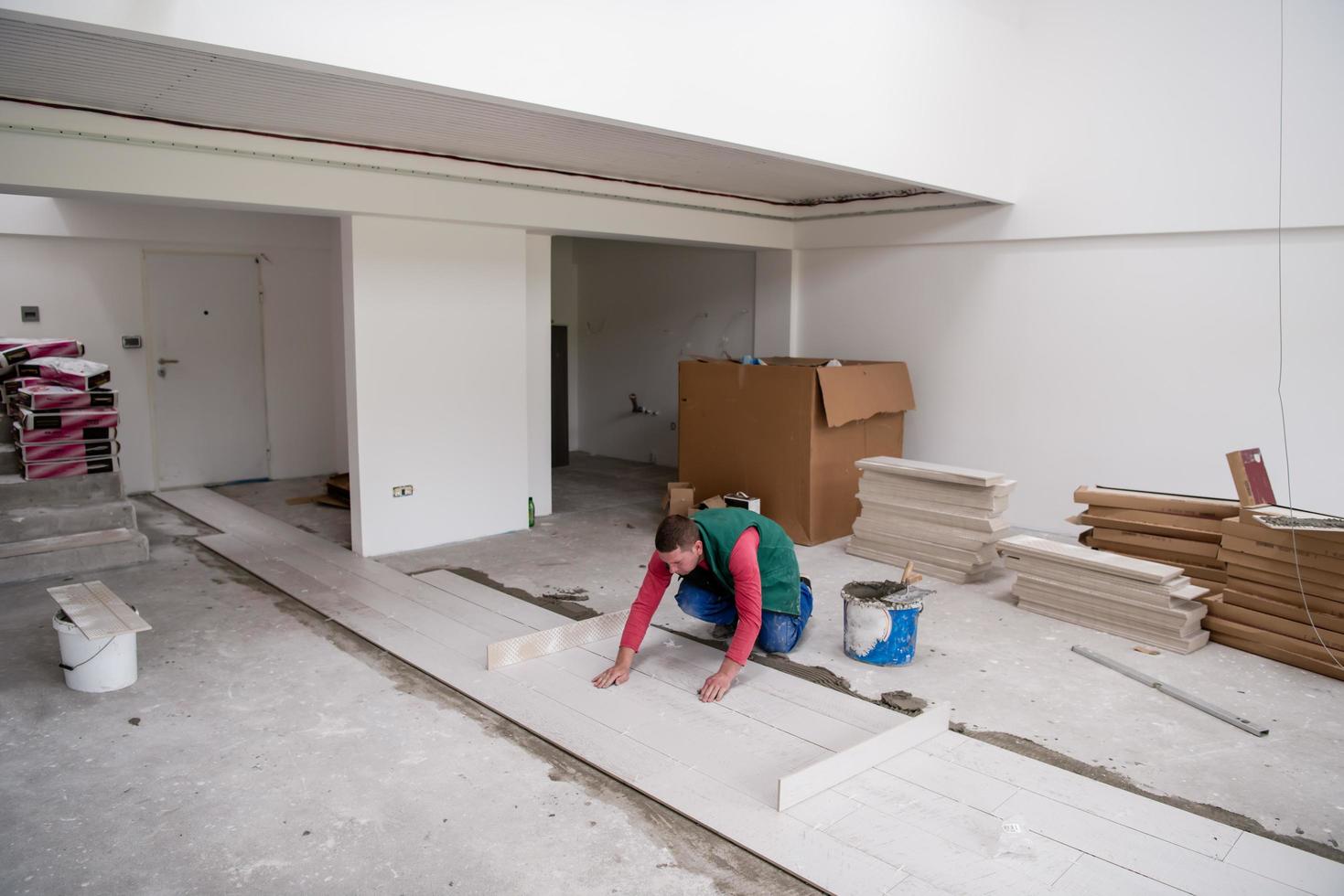 worker installing the ceramic wood effect tiles on the floor photo