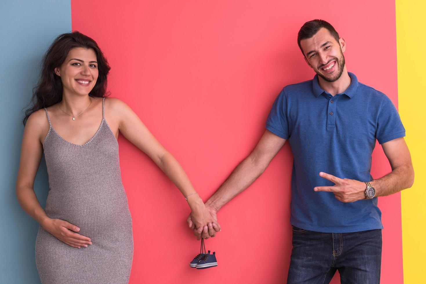 joven pareja feliz sosteniendo zapatos de bebé recién nacido foto