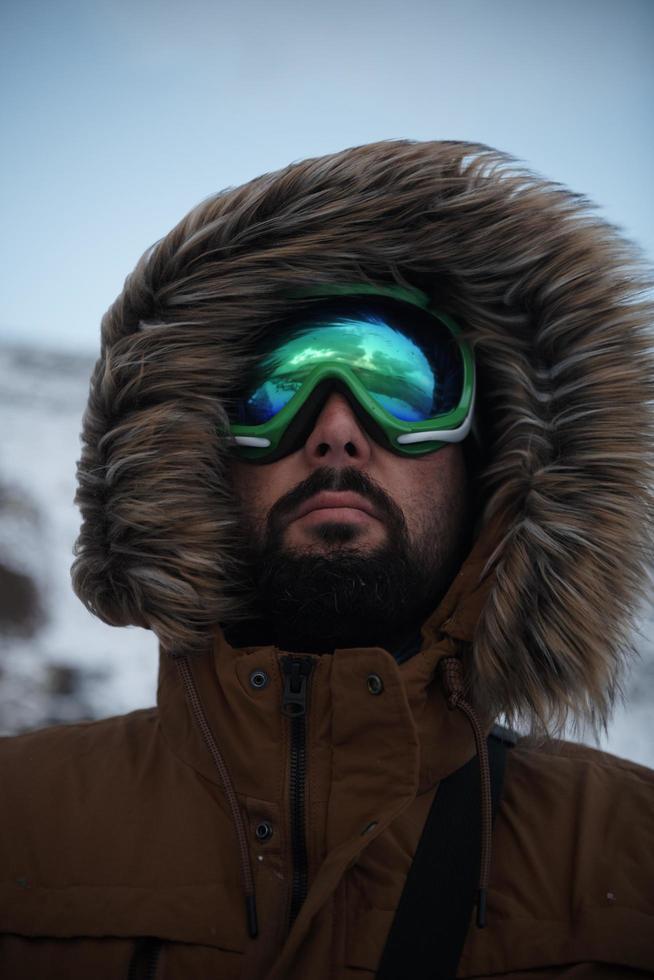 man at winter in stormy weather wearing warm  fur jacket photo
