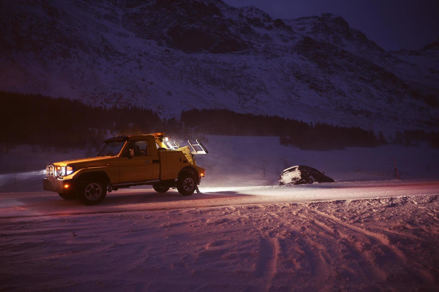 coche siendo remolcado después de un accidente en una tormenta de nieve foto