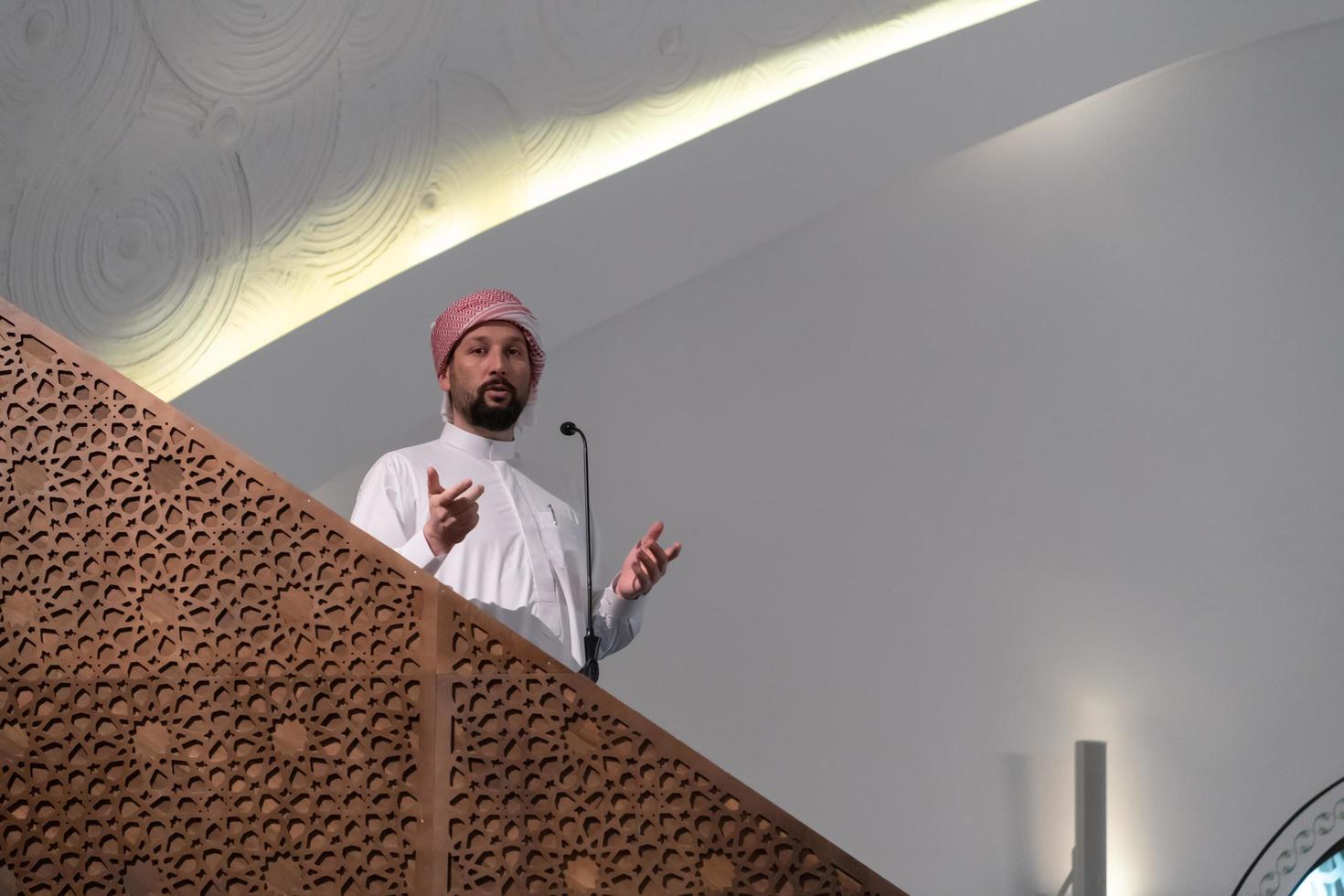 Muslims young arabic Imam has a speech on friday afternoon prayer in mosque. photo