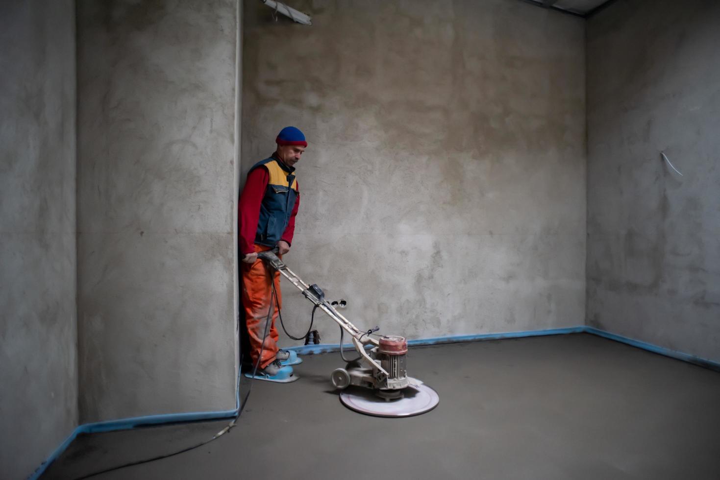 trabajador realizando y puliendo suelo de solera de cemento y arena foto