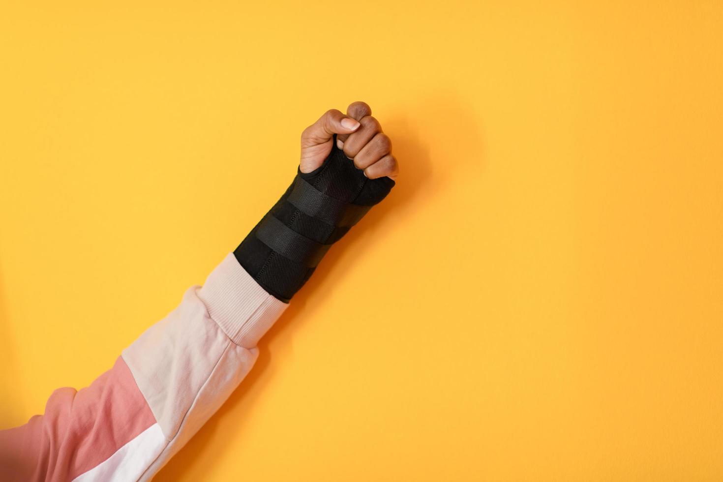 hand injury. a female injured hand on a yellow background photo