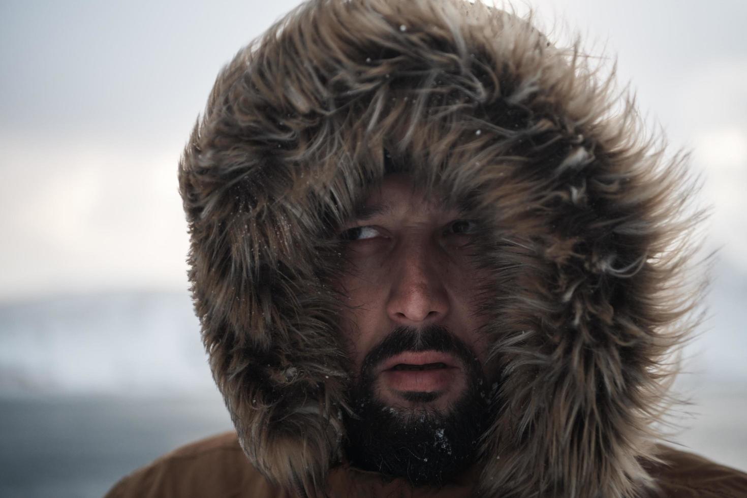 man at winter in stormy weather wearing warm  fur jacket photo