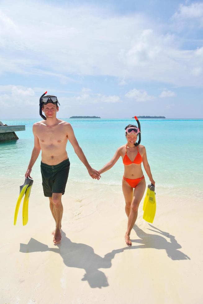 feliz pareja joven divertirse en la playa foto