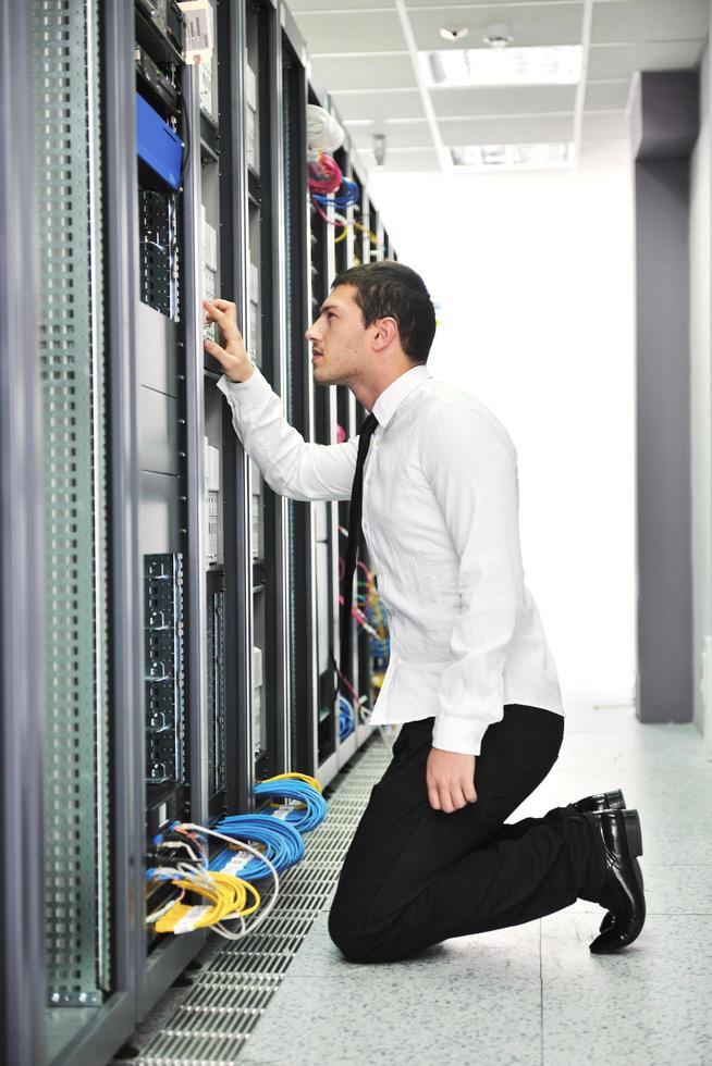 young engeneer in datacenter server room photo