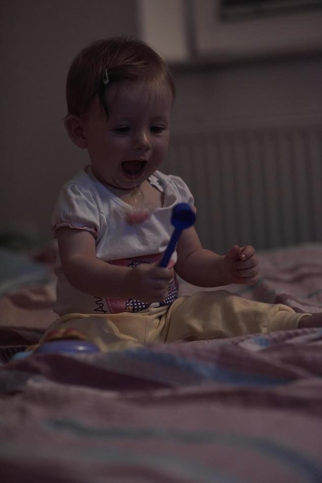 lindo bebé de un año y dando los primeros pasos en la cama foto