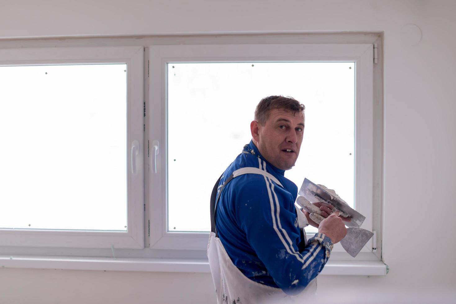 construction worker plastering on gypsum walls photo