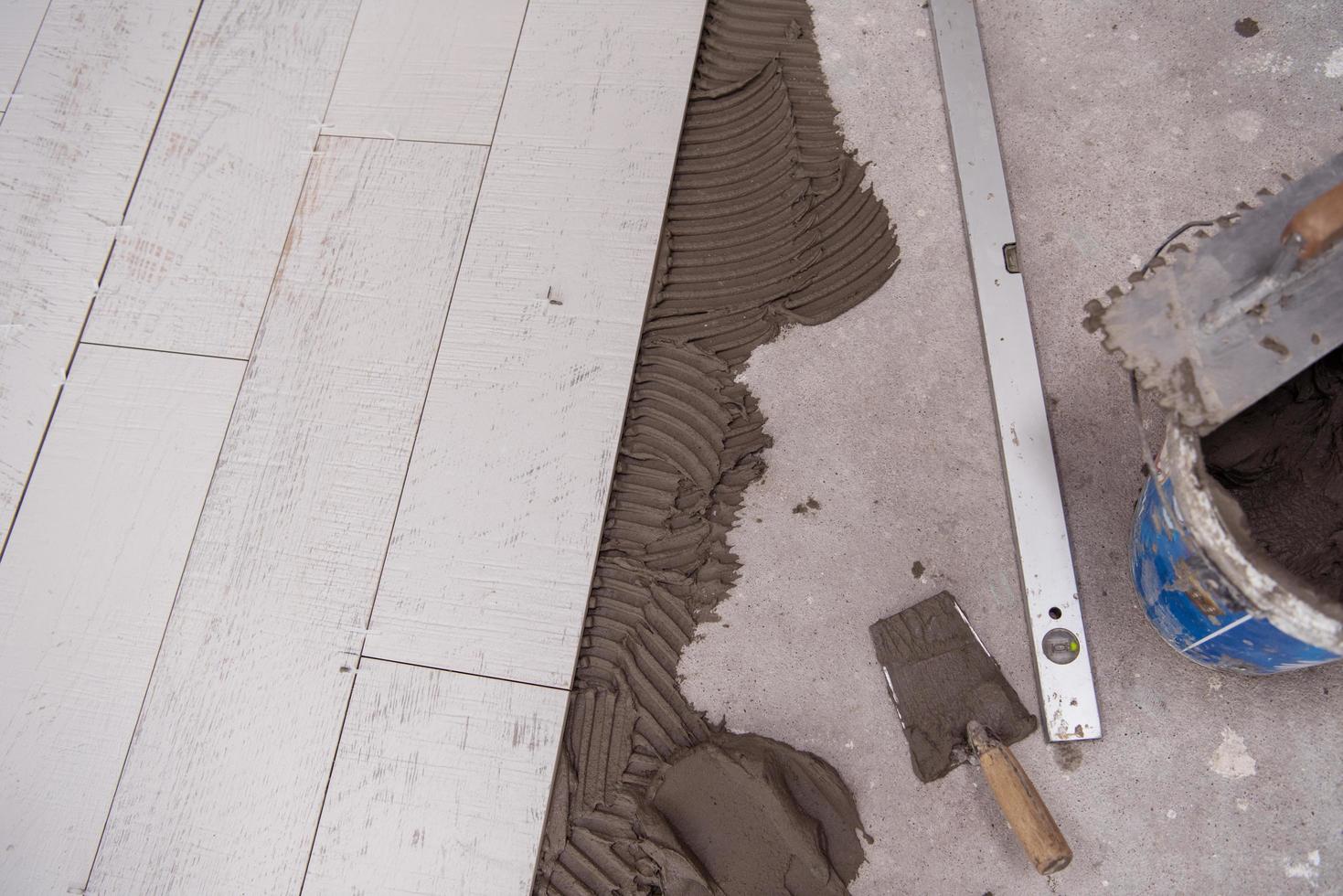 Ceramic wood effect tiles and tools for tiler on the floor photo
