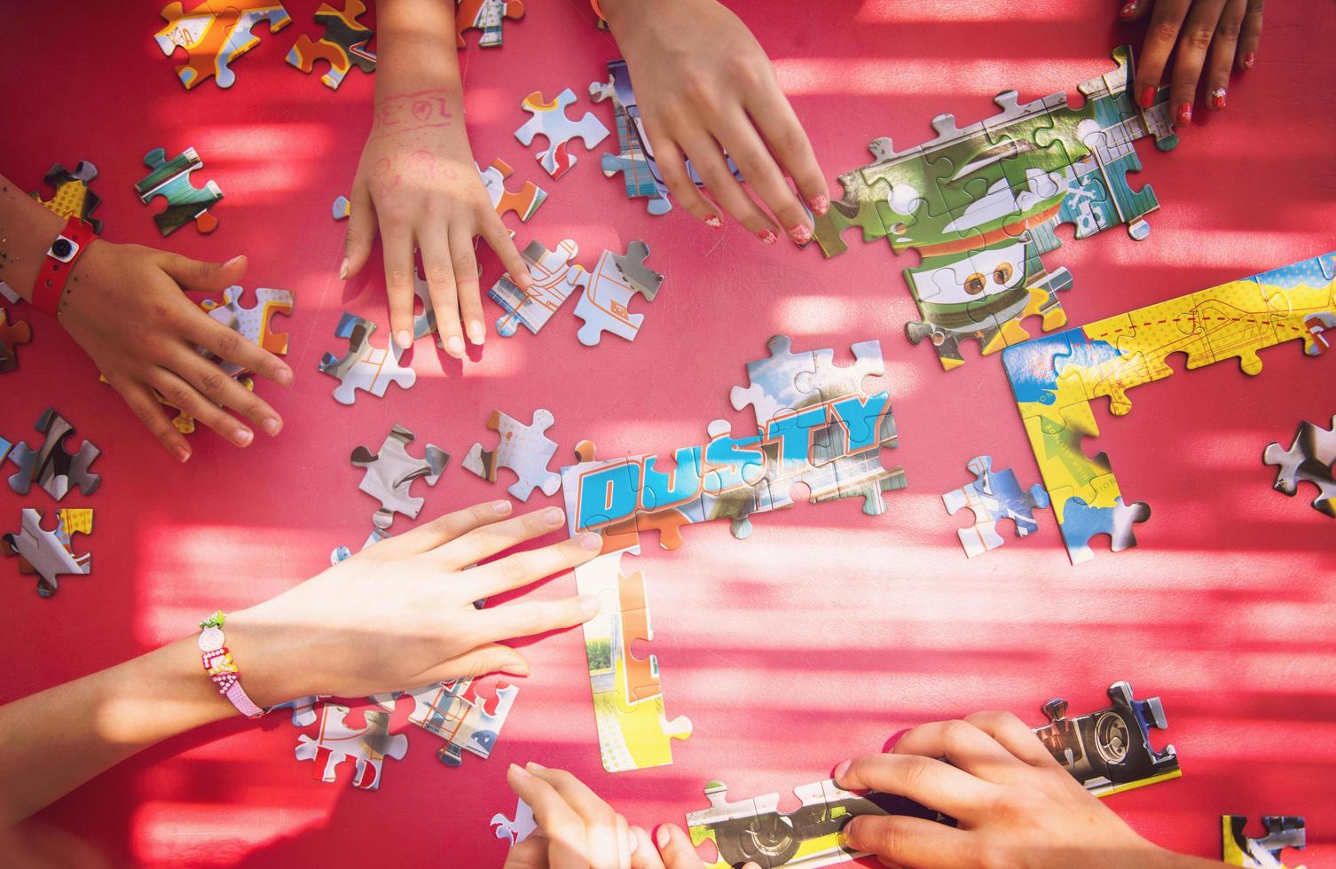 top view of kids hands playing with puzzles photo