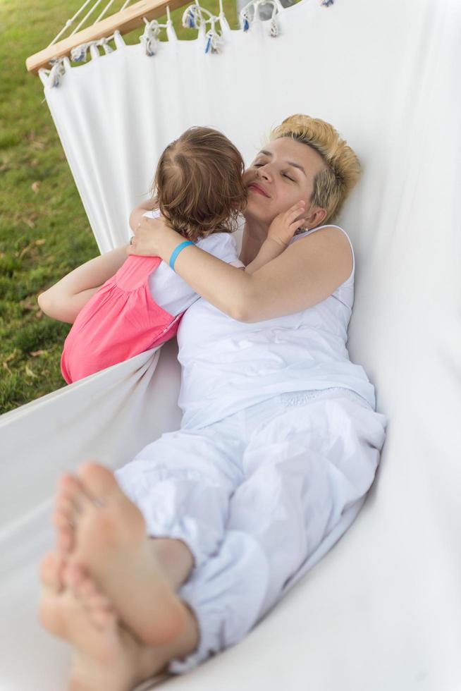 mother and a little daughter relaxing in a hammock photo