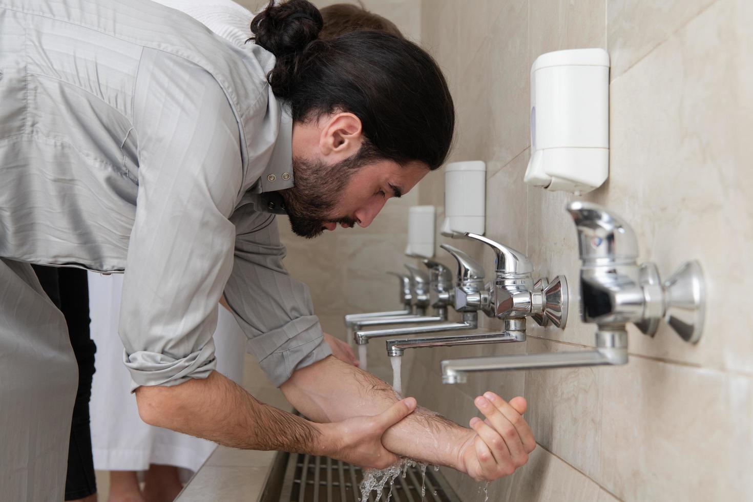 a group of Muslims take ablution for prayer. Islamic religious rite photo