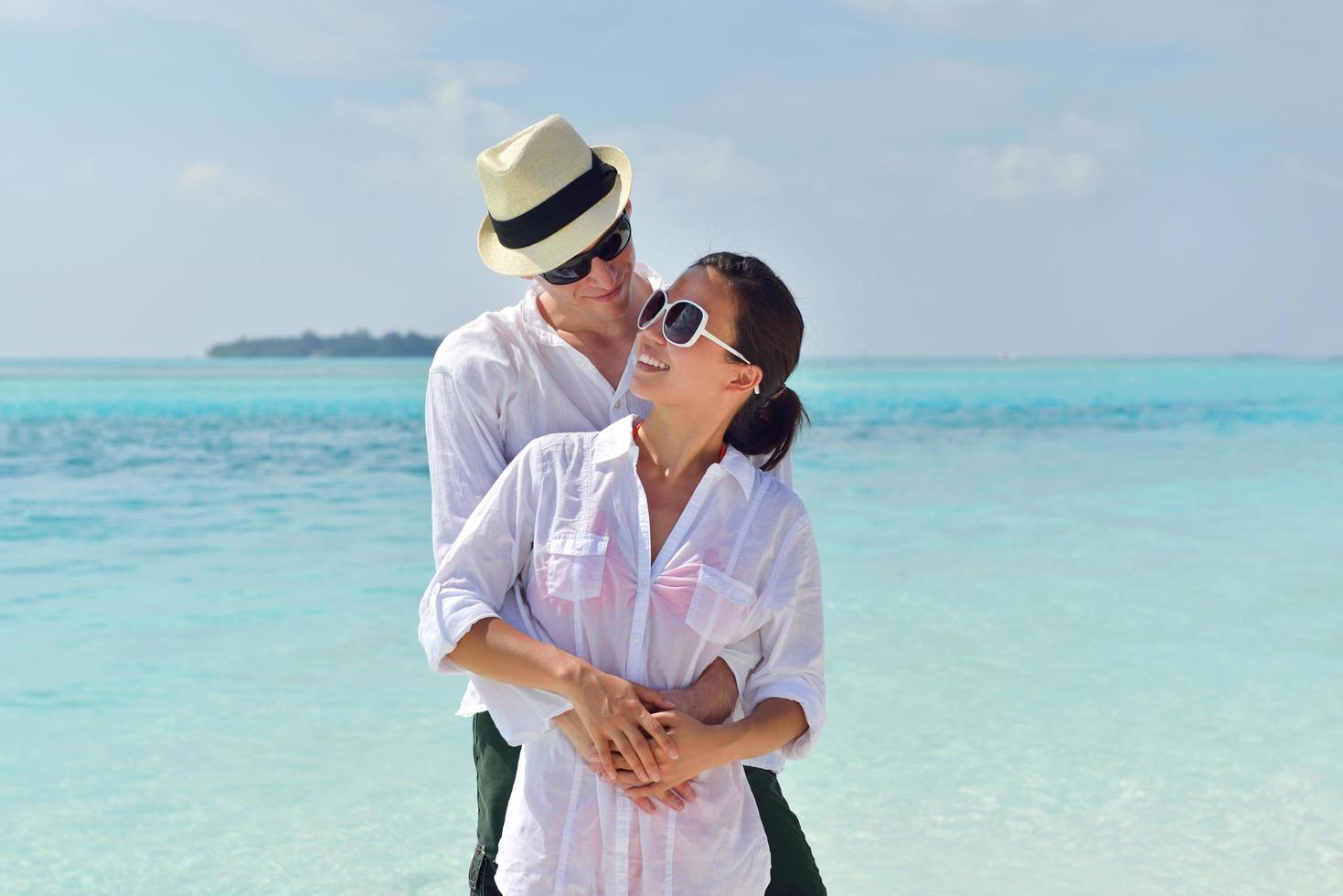 feliz pareja joven divertirse en la playa foto