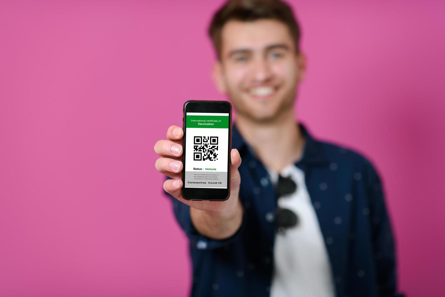 covid passport, a young man shows his code and covid passport on his cell phone photo