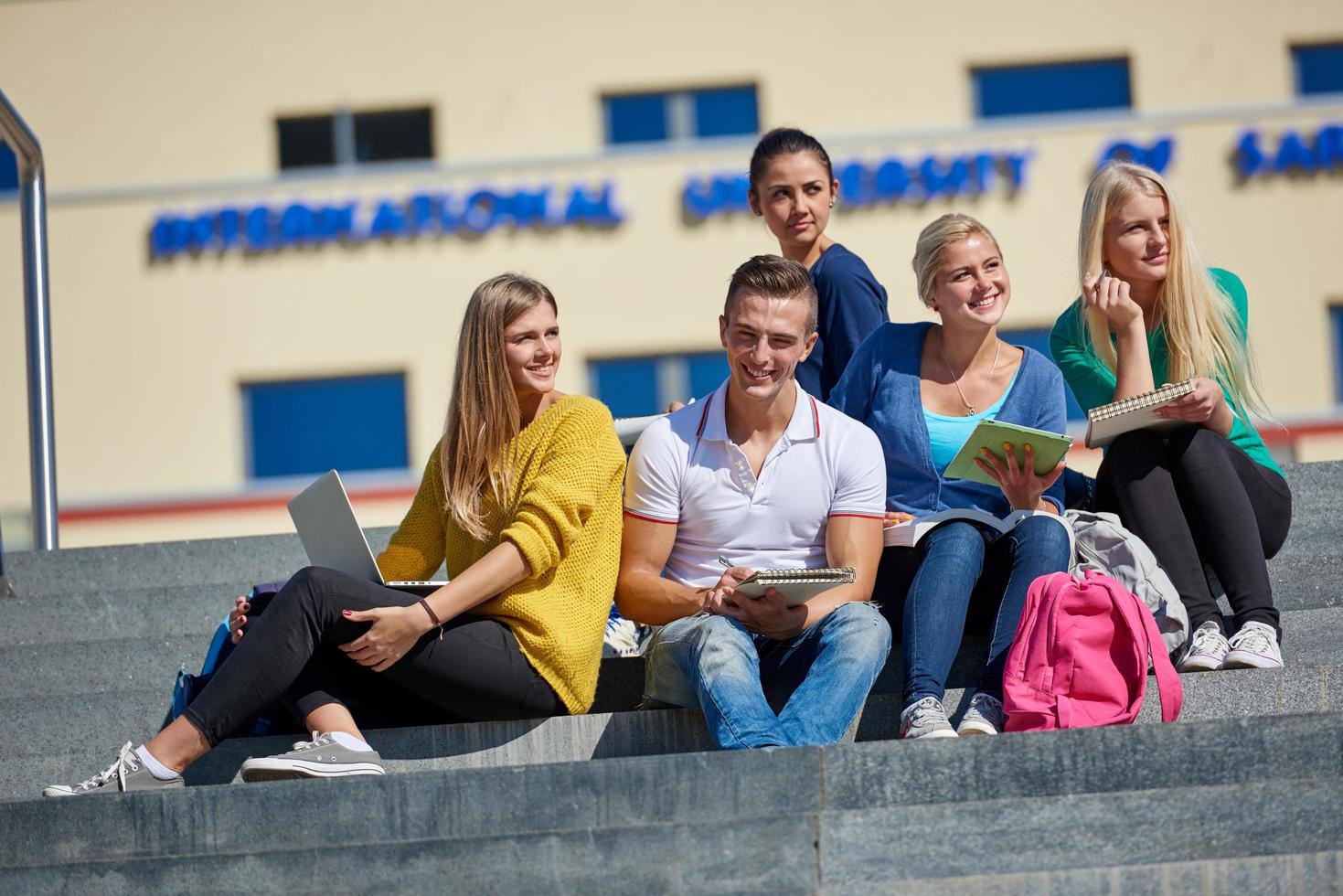 students outside sitting on steps photo