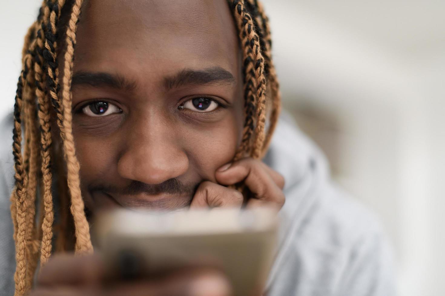 afro guy uses a cell phone and browses social media during a pandemic photo