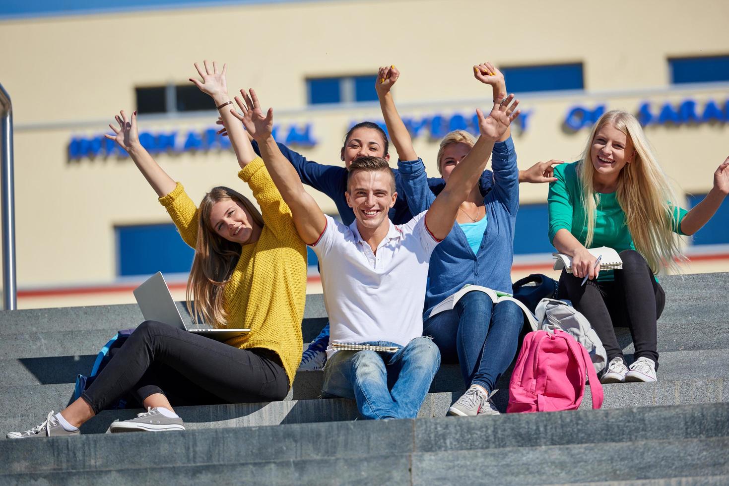 estudiantes afuera sentados en escalones foto