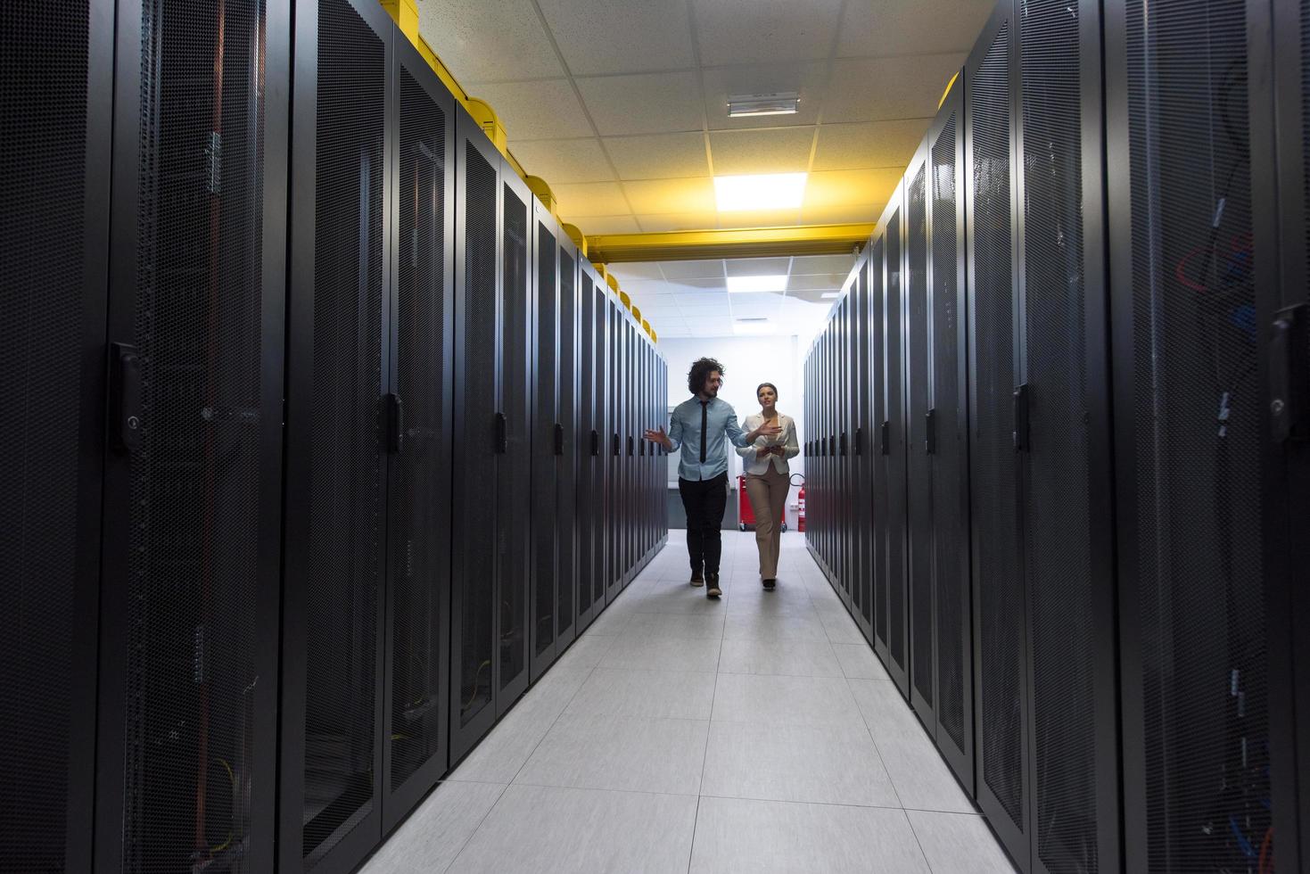 ingeniero que muestra la sala de servidores del centro de datos en funcionamiento a la jefa foto