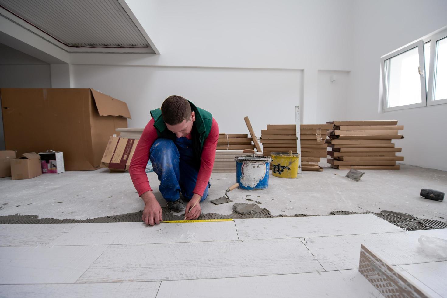 worker installing the ceramic wood effect tiles on the floor photo