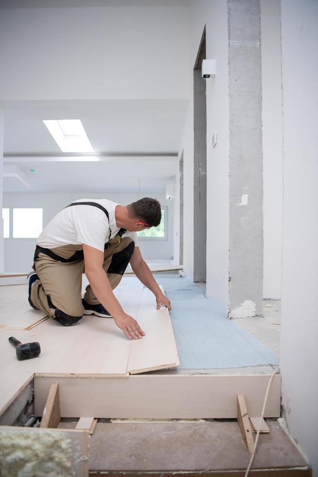 Worker Installing New Laminated Wooden Floor photo
