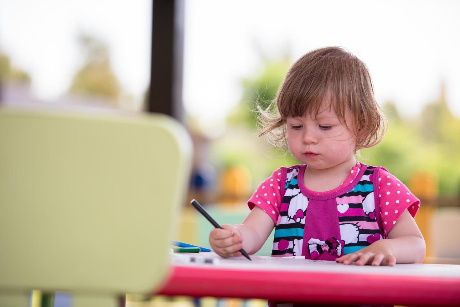 little girl drawing a colorful pictures photo