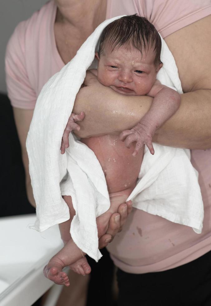 Grandmother is bathing Newborn baby girl photo