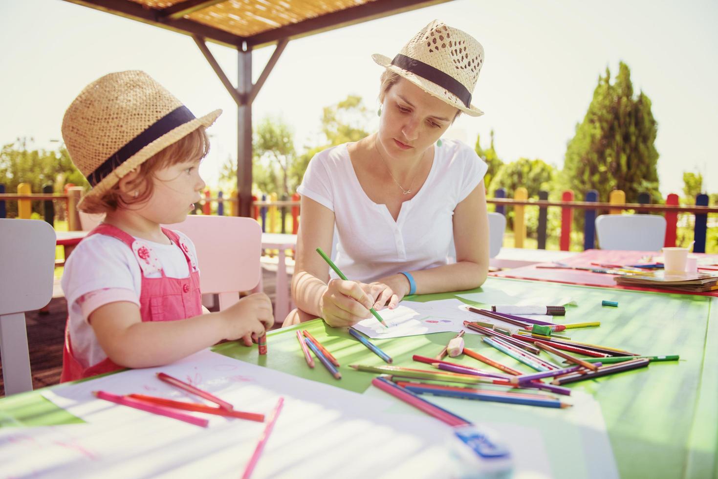 mom and little daughter drawing a colorful pictures photo