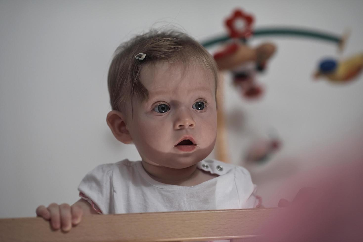 lindo bebé de un año y dando los primeros pasos en la cama foto