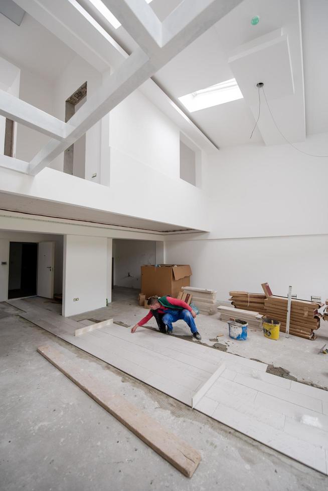 worker installing the ceramic wood effect tiles on the floor photo