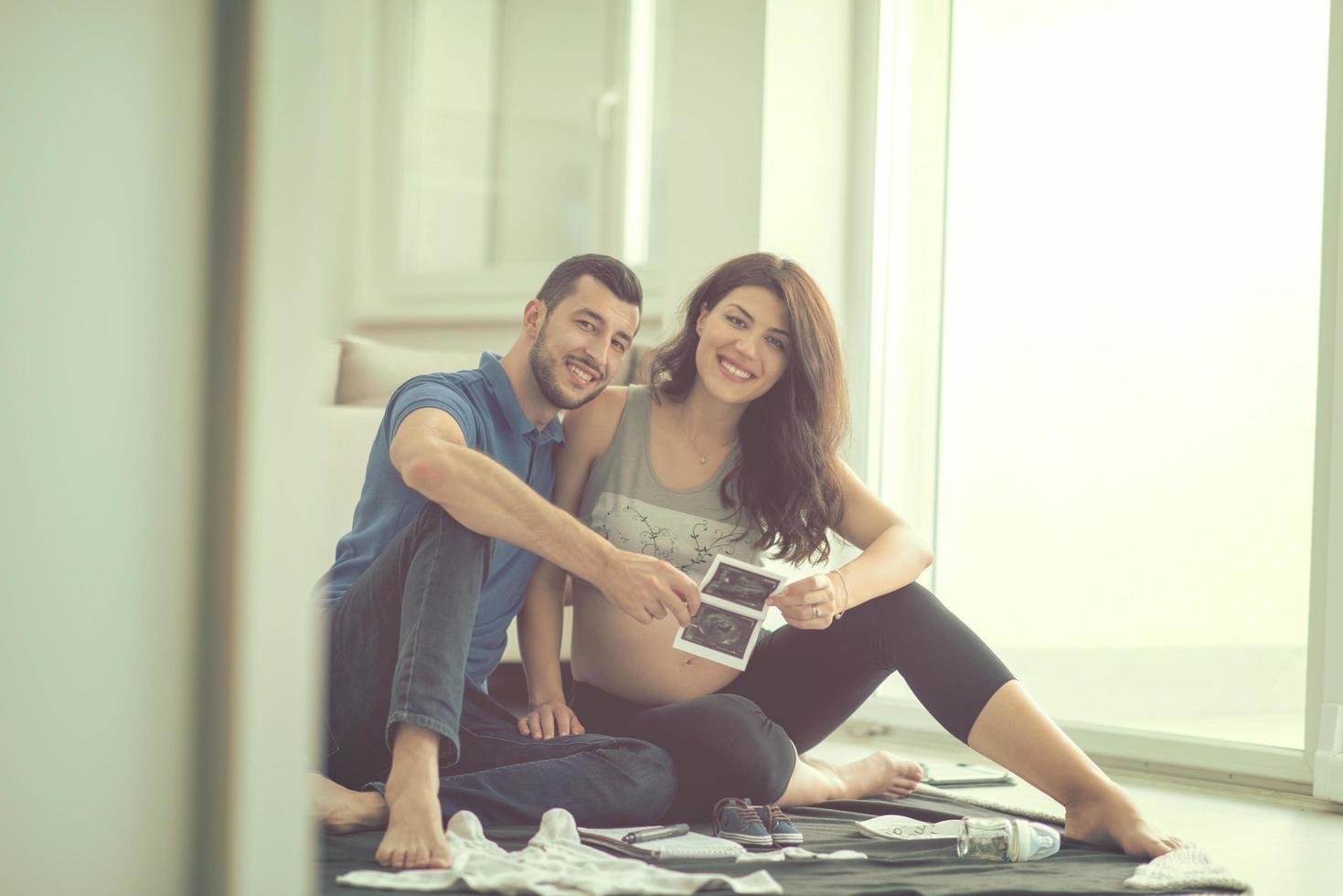 pregnant couple checking a list of things for their unborn baby photo