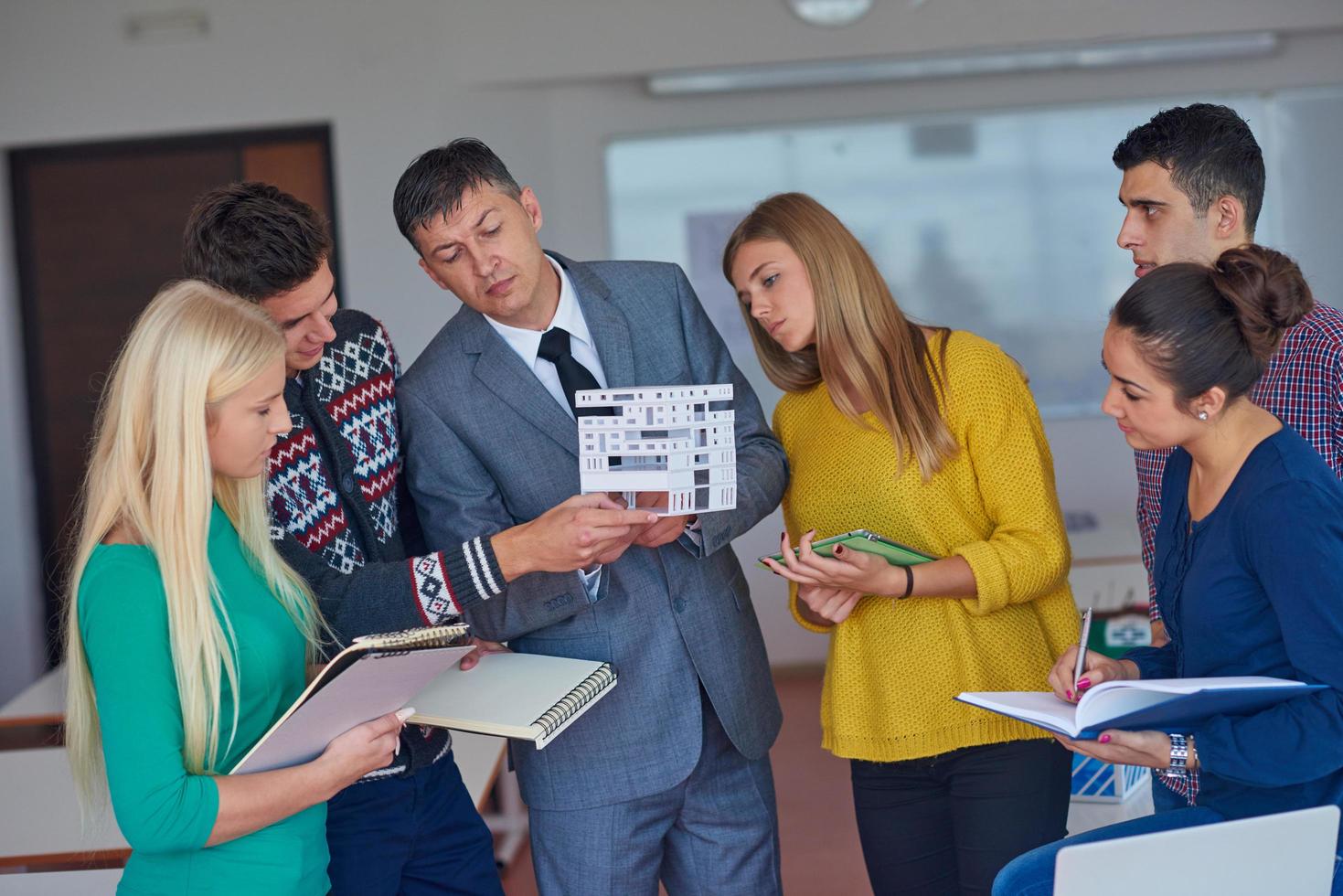 group of students working with teacher on  house model photo