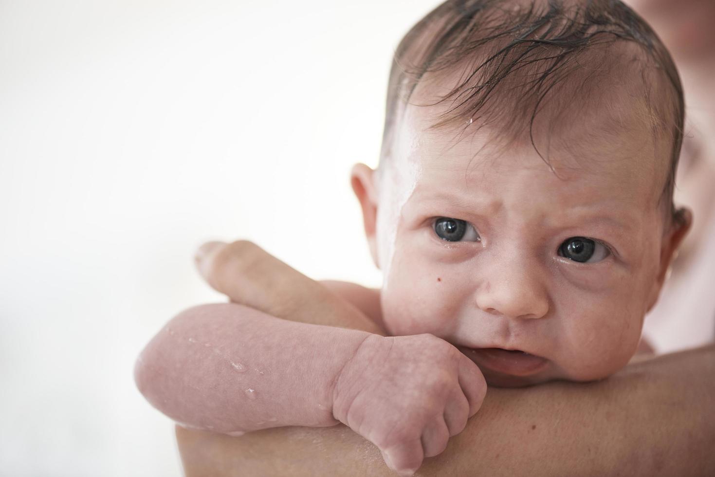 Newborn baby girl taking a  bath photo