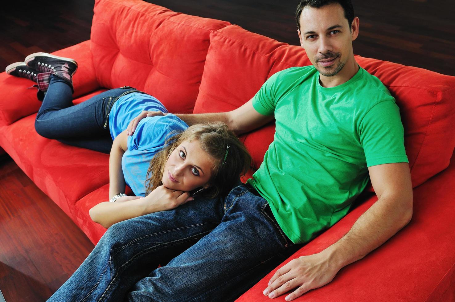 happy couple relax on red sofa photo