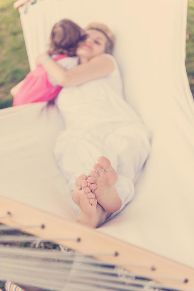 mother and a little daughter relaxing in a hammock photo