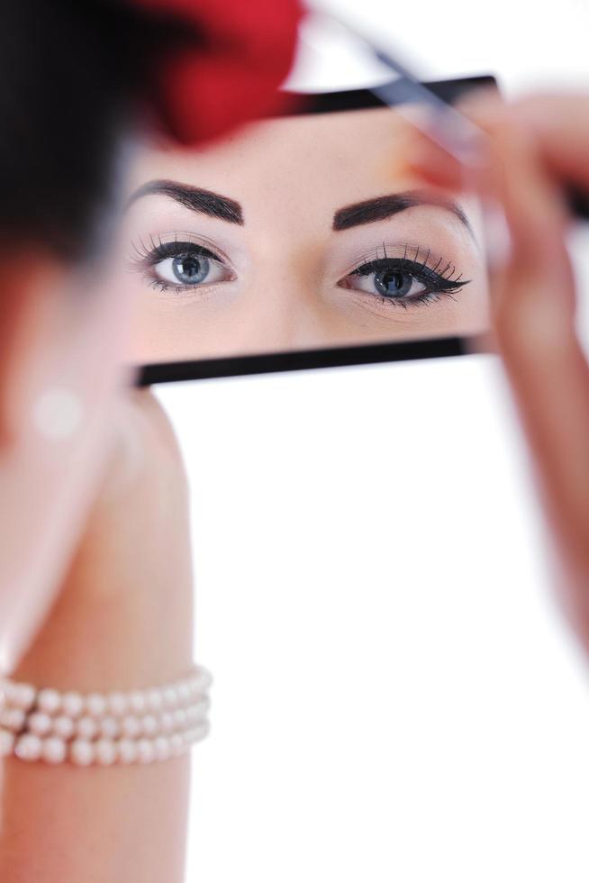 beautiful young woman applying makeup photo