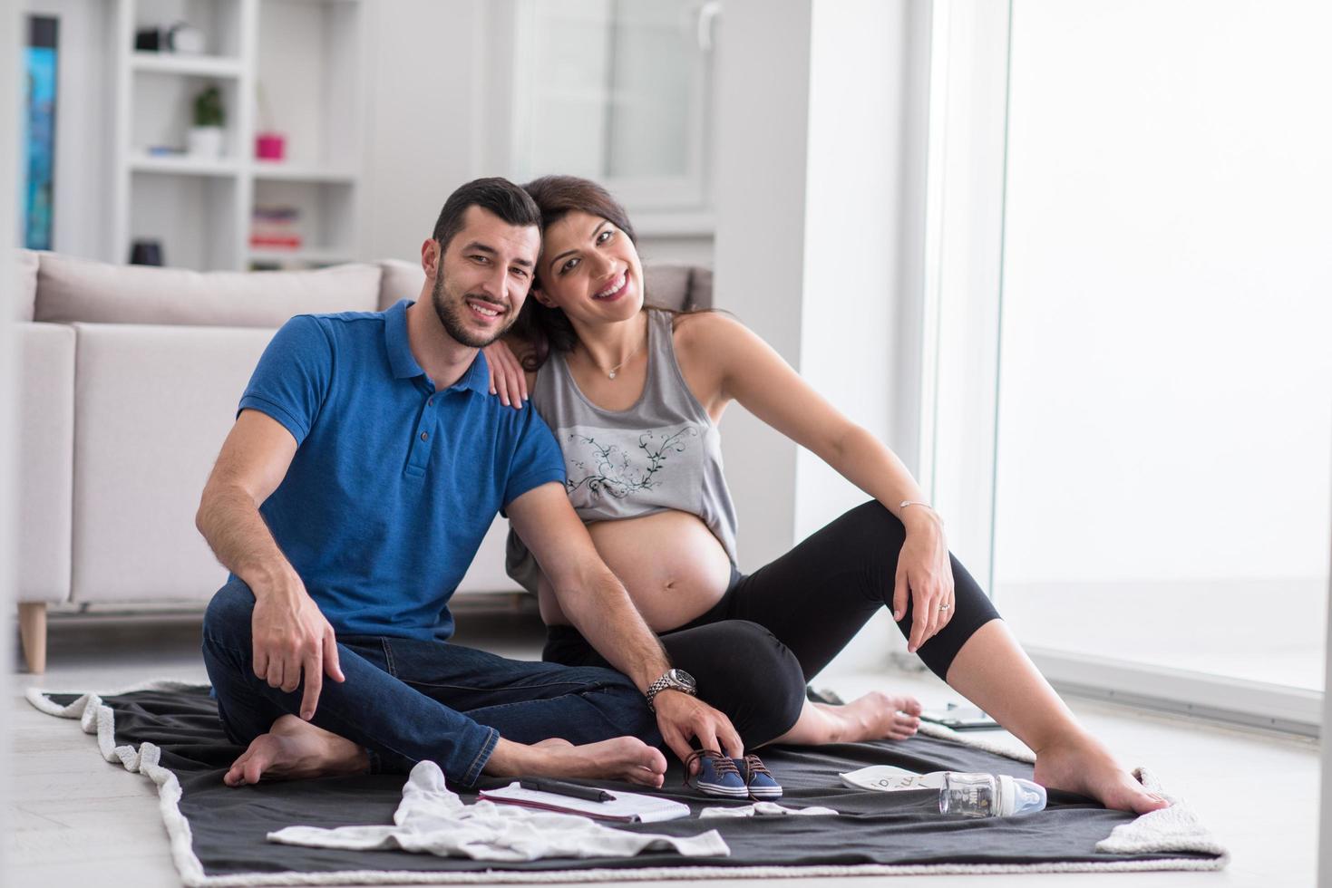 pregnant couple checking a list of things for their unborn baby photo