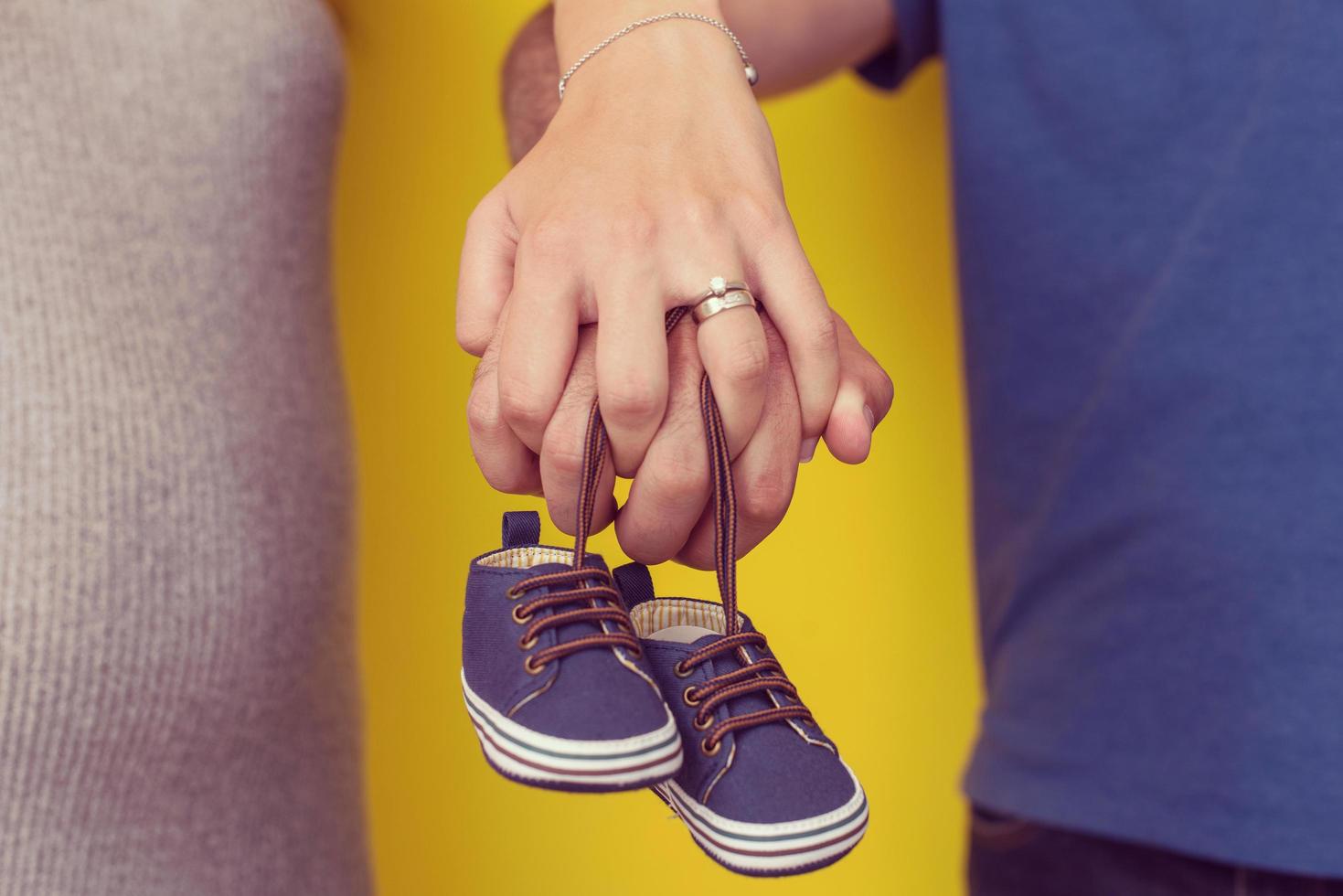 couple holding newborn baby shoes photo