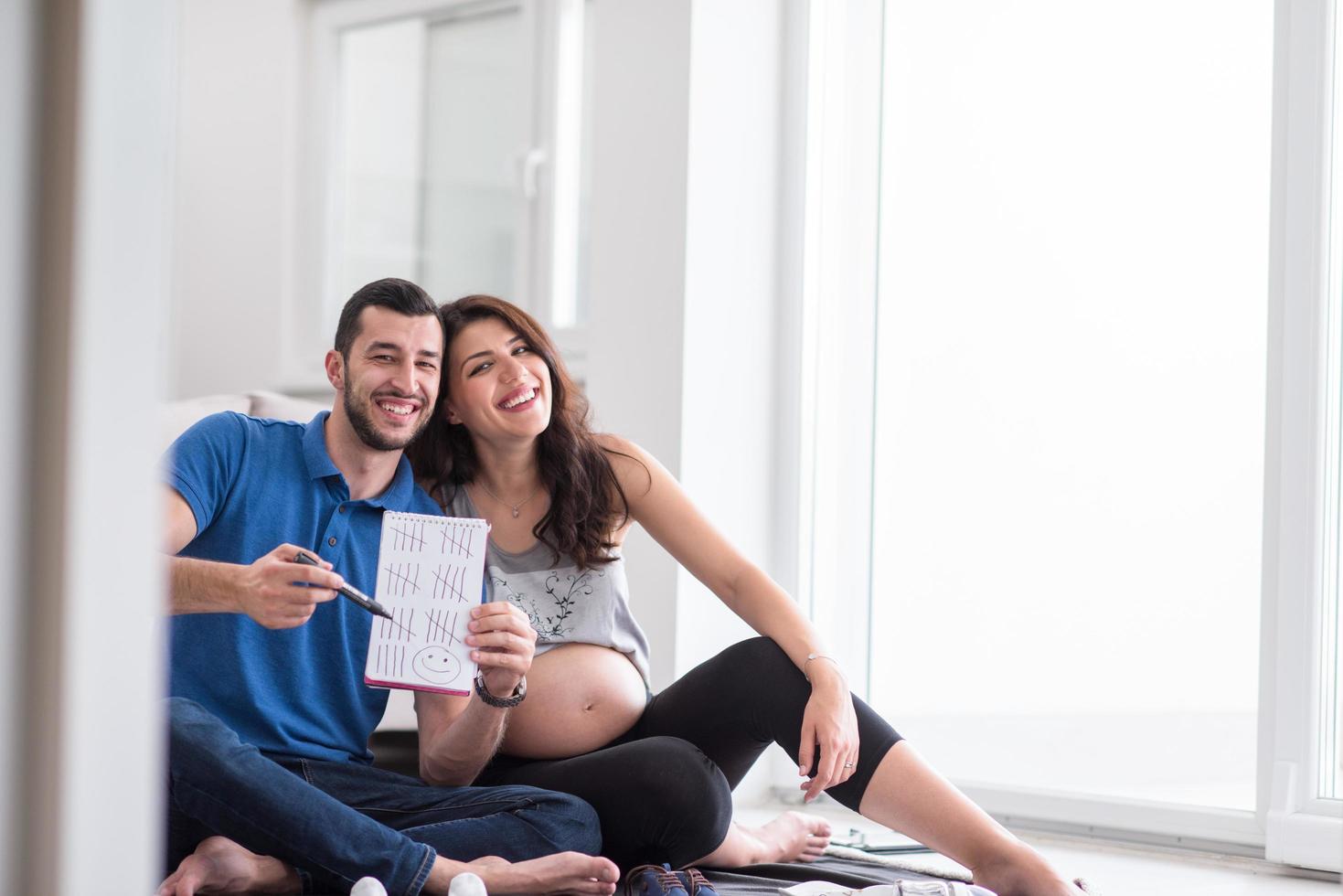 pregnant couple checking a list of things for their unborn baby photo