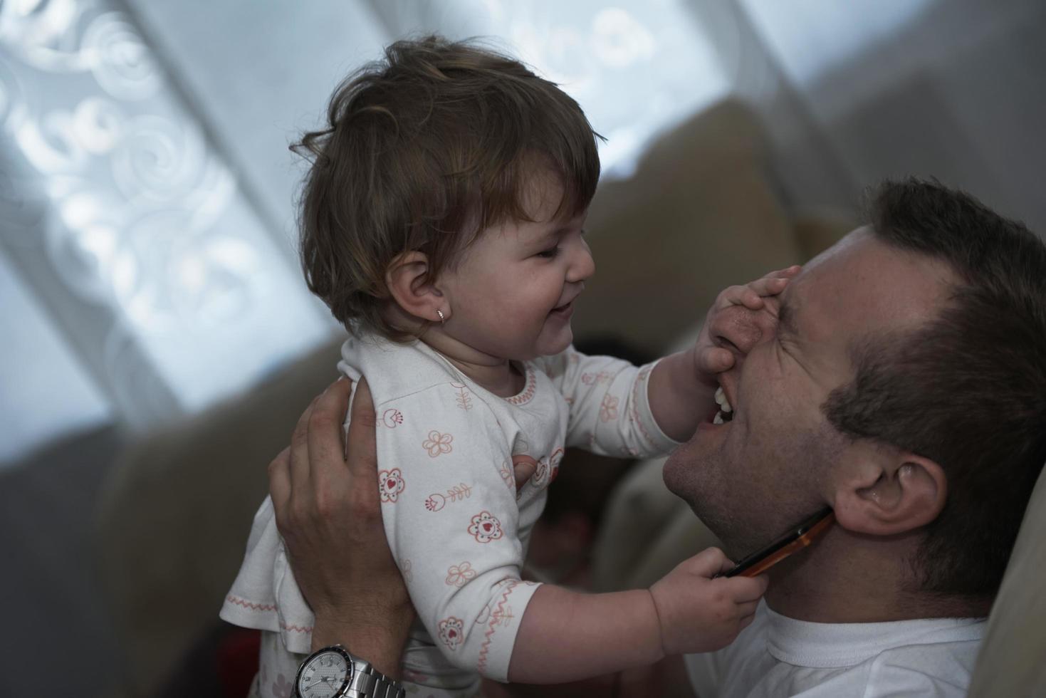 padre sosteniendo y besando al pequeño bebé foto