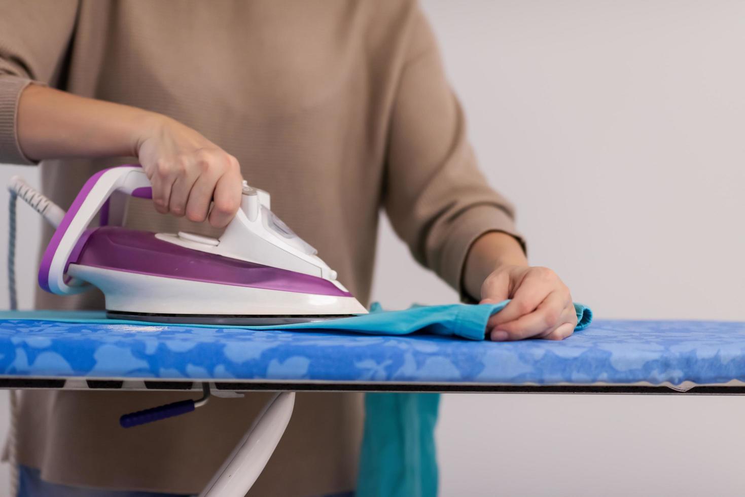 mujer pelirroja planchando ropa en casa foto