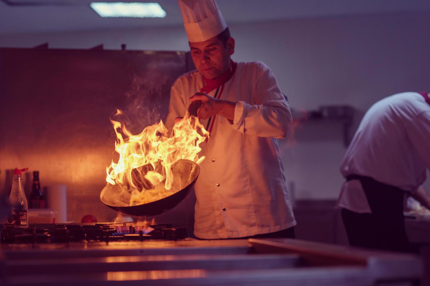 chef haciendo flambeado en la comida foto