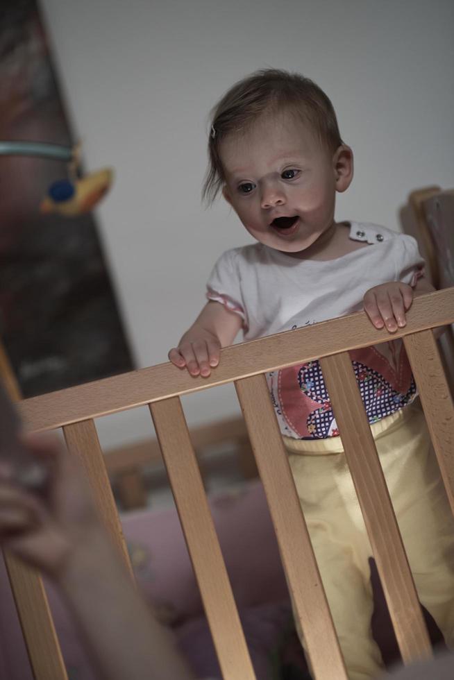 lindo bebé de un año y dando los primeros pasos en la cama foto