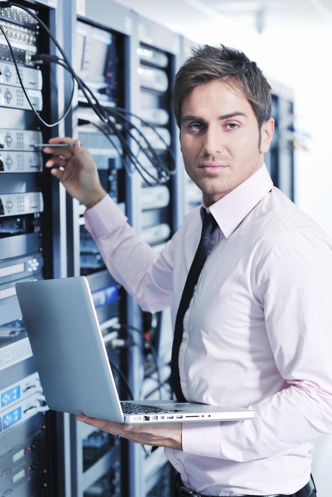 businessman with laptop in network server room photo