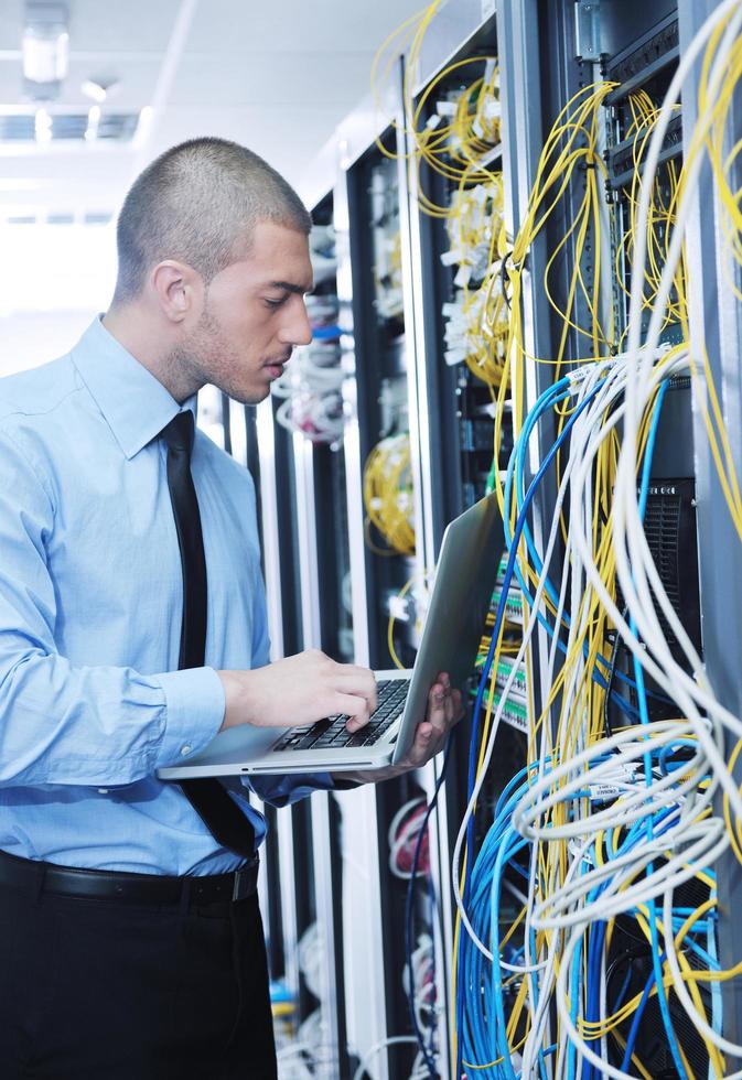 businessman with laptop in network server room photo