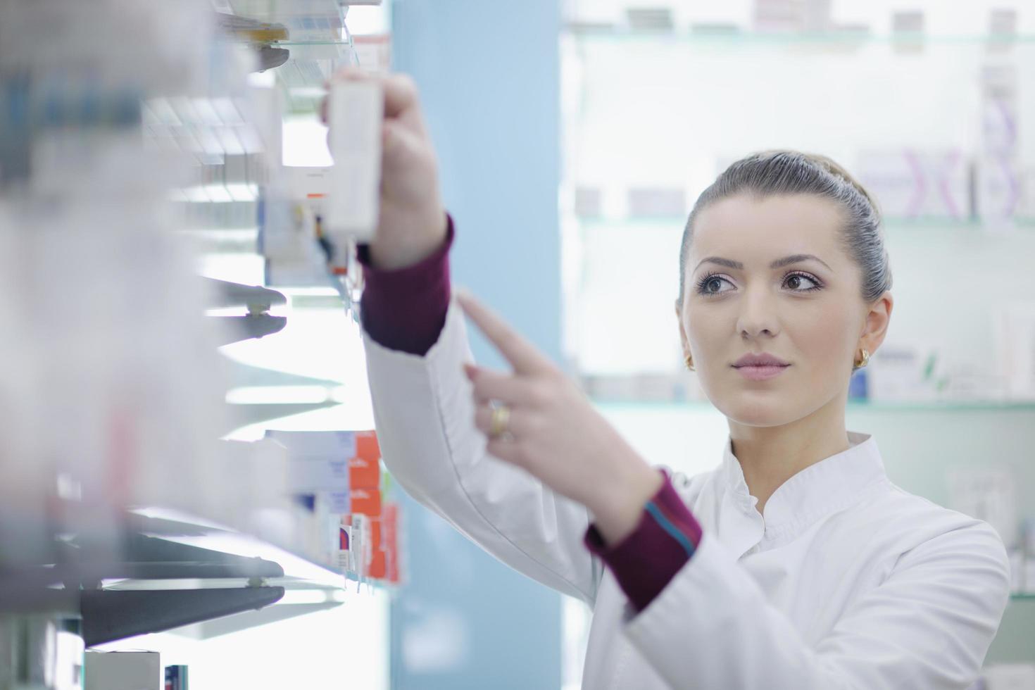 Farmacéutico químico mujer de pie en farmacia droguería foto