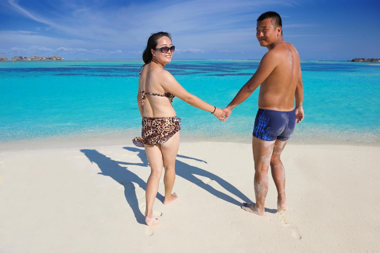 happy young  couple enjoying summer on beach photo