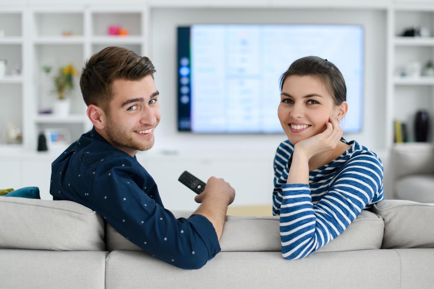 una joven pareja casada disfruta sentarse en la gran sala de estar foto